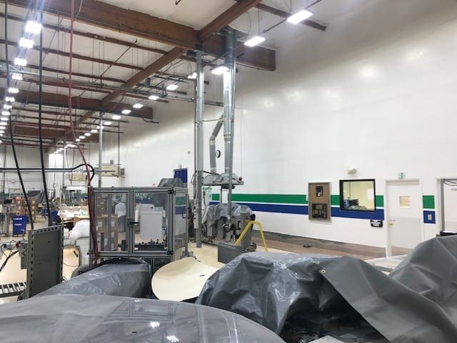 Arizona Painting Company's skilled industrial painters providing durable protective coatings for machinery and structures, enhancing both longevity and aesthetics. Painters painting an industrial room with blue and green stripes.