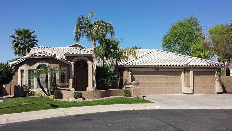 Large and Beautiful Brown home with palm trees in the front transformed by Arizona Painting Company: A beautifully painted residential exterior, showcasing a rich and inviting color, exemplifying the skillful craftsmanship and dedication of Arizona Painting Company.