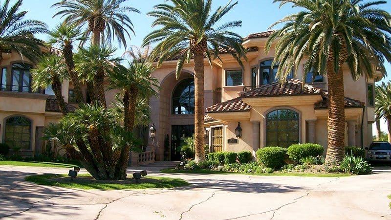 Large and Beautiful Brown home with palm trees in the front transformed by Arizona Painting Company: A beautifully painted residential exterior, showcasing a rich and inviting color, exemplifying the skillful craftsmanship and dedication of Arizona Painting Company.
