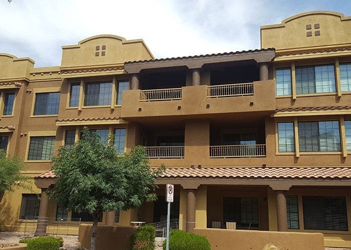 Arizona Painting Company's expert team offering HOA's painting services, revitalizing community properties with quality coatings for lasting beauty and enhanced curb appeal. Brown residential building being shown in image for HOA painting.