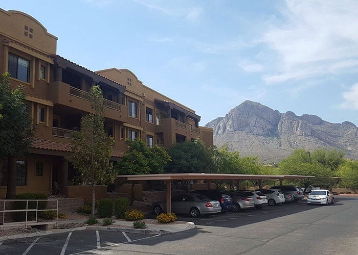 Arizona Painting Company's expert team offering HOA painting services, revitalizing community properties with quality coatings for lasting beauty and enhanced curb appeal. Large brown apartment building is shown in the picture.