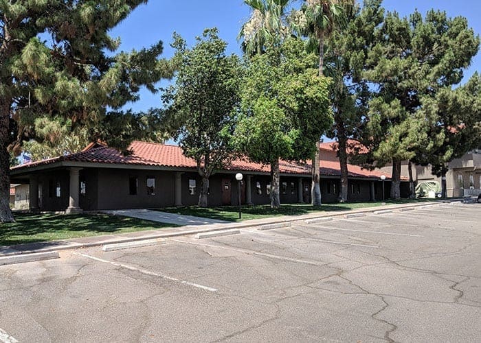 Arizona Painting Company's expert team offering HOA painting services, revitalizing community properties with quality coatings for lasting beauty and enhanced curb appeal. Brown residential building being shown in image.