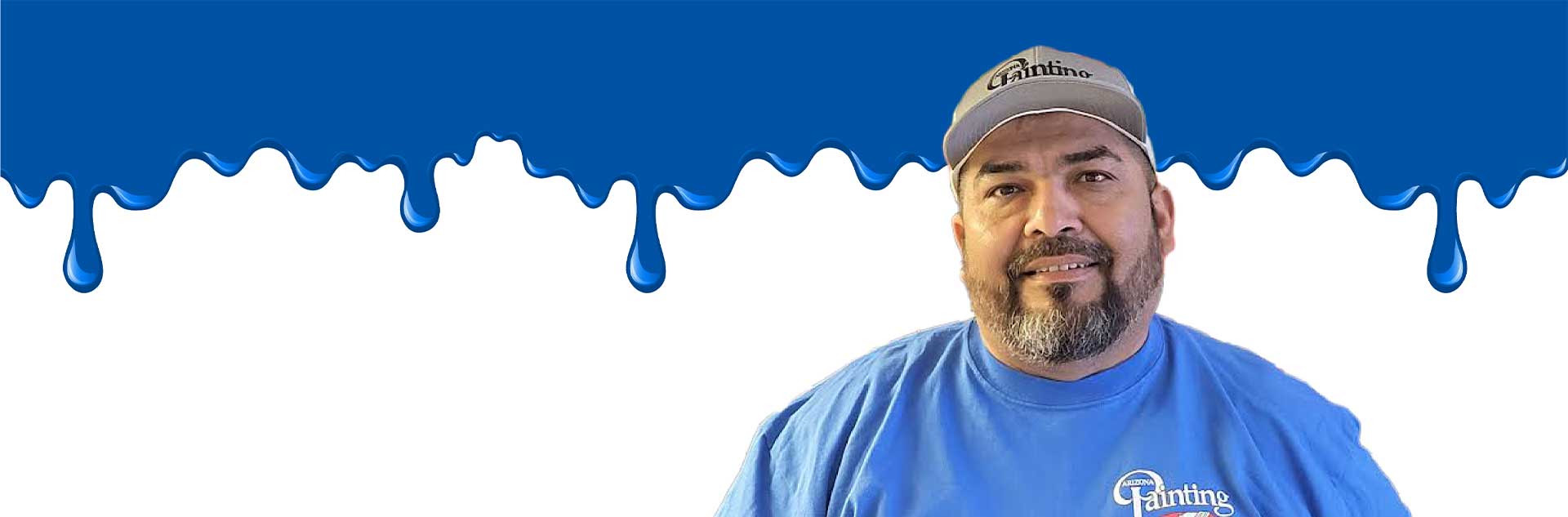 Ruben is shown in the image as the featured employee of Arizona Painting Company. He is shown wearing a long sleeve company shirt against a white background with blue paint drips matching his blue shirt.